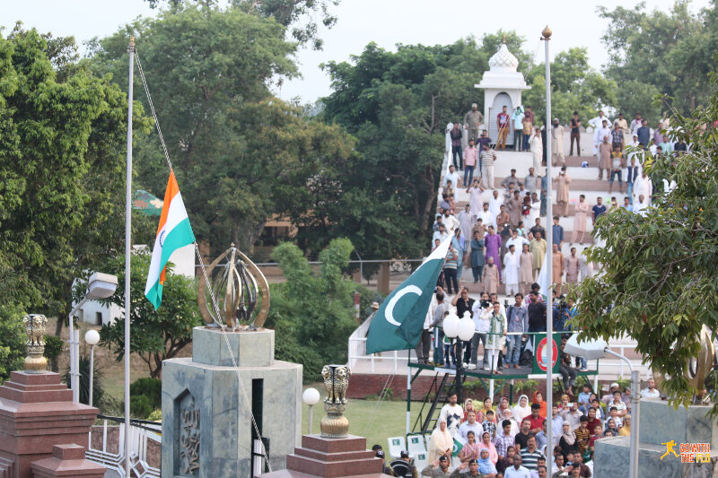 The two flags being lowered in unison