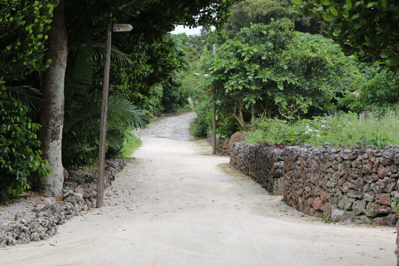 "traditional Okinawan" houses, stone walls, and sandy streets